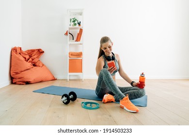 Smiling caucasian woman resting on a mat at home while watching typing messages or using app on the mobile phone - Powered by Shutterstock