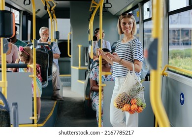 Smiling Caucasian Young Adult Woman, Going From Shopping, Holding Mash Bag With Groceries And Going Home By Bus