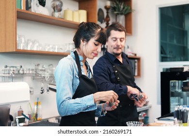 Smiling Caucasian Young barista couple love is wearing apron and cleaning a cup for working in the coffee shop. They are happy for start up small cafe business concept.  - Shutterstock ID 2160269171