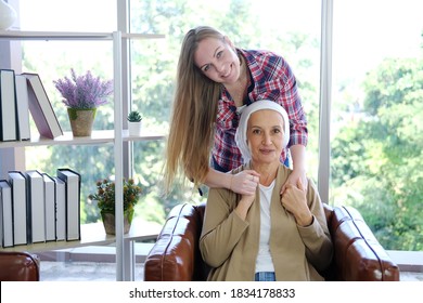 Smiling Caucasian Young Daughter Is Hugging Her Elderly Mother In White Headscarf After Chemotherapy Because She Is Suffering From Cancer Or Leukemia Patient.