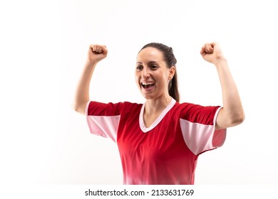 Smiling caucasian young female player with arms raised and clenched fist against white background. unaltered, sport, sports uniform, victory, athlete and women's soccer. - Powered by Shutterstock