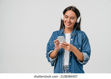 Smiling caucasian young woman listening to the podcast e-book music song singer rock band in headphones earphones, choosing sound track on cellphone isolated in white background - Shutterstock ID 2138384507