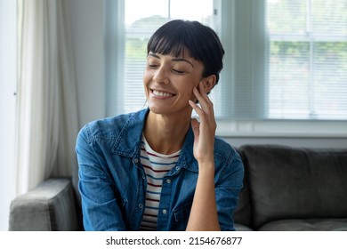 Smiling caucasian young woman sitting with eyes closed at home. unaltered, lifestyle, domestic life, contemplation. - Shutterstock ID 2154676877