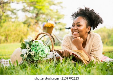 Smiling charming African American woman in imagined dreaming and happiness after reading the book during the picnic on the sunny meadow. - Powered by Shutterstock