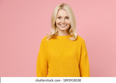 Smiling Cheerful Beautiful Elderly Gray-haired Blonde Woman Lady 40s 50s Years Old Wearing Yellow Casual Sweater Standing And Looking Camera Isolated On Pastel Pink Color Background Studio Portrait