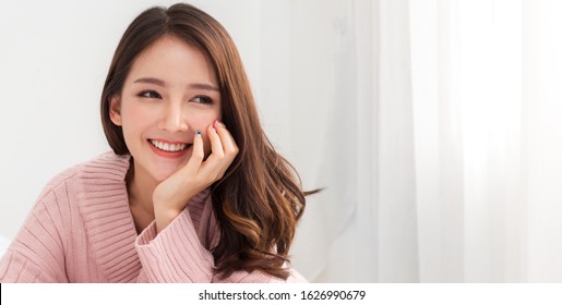 Sorrindo de alegre linda mulher asiática bonita limpa pele branca fresca e saudável posando em roupas quentes de malha cor-de-rosa.Menina sentindo relaxante e aproveitar o tempo na cama em casa.asia beleza