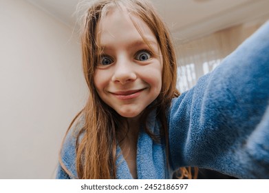 Smiling cheerful beautiful red-haired little girl, child teenager takes pictures of howling face holding camera, smartphone, phone in hands, laughing, grimacing. Photography, portrait, lifestyle. - Powered by Shutterstock