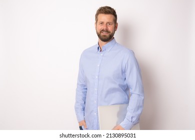 Smiling cheerful caucasian business man in glasses wearing classic shirt, standing with laptop isolated over white background. Business concept.