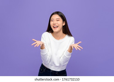 Smiling cheerful cute Asian woman in casual attire doing blowing kiss gesture with open palms isolated on purple studio background - Powered by Shutterstock