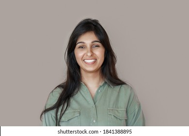 Smiling cheerful young adult indian woman looking at camera, happy pretty funny lady model laughing, feeling positive emotion standing isolated on brown background, face front headshot portrait. - Shutterstock ID 1841388895