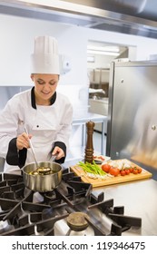 Smiling Chef Making Soup In Kitchen