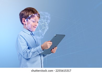 Smiling child boy with tablet in hands, portrait profile with biometric verification hologram and facial recognition. Concept of face id and artificial intelligence