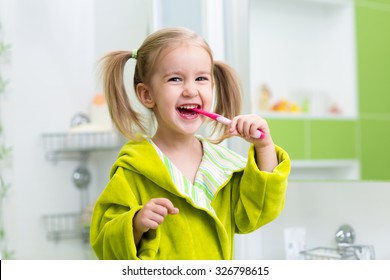 Smiling Child Kid Girl Brushing Teeth In Bathroom