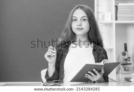 smiling child making notes in notebook. back to school. teen girl ready to study.