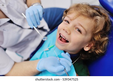 Smiling Child Sitting In A Blue Chair Dental