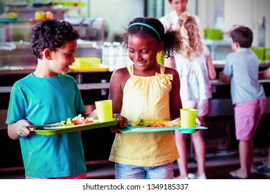 Smiling Children Holding Food Tray In Canteen At School