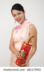 Smiling Chinese Woman Dress Traditional Cheongsam Holding A Big Fire Cracker With Text Greeting For Chinese New Year