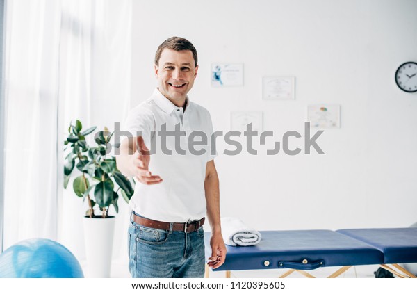Smiling Chiropractor Outstretched Hand Looking Camera Stock Photo Edit Now