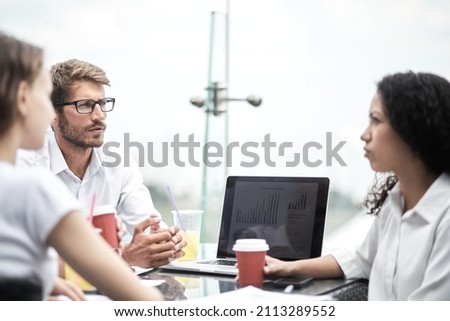 Smiling colleagues working together developing business strategy for their next project. asually dressed business people having discussion on sunny terrace. Modern job in comfortable conditions