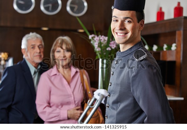 Smiling concierge\
with senior couple in a\
hotel