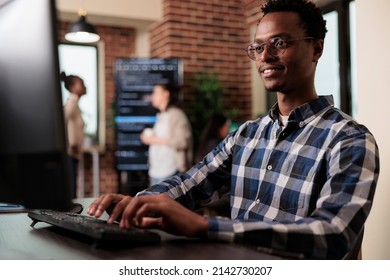 Smiling Confident African American Software Engineer Developing Machine Learning Algorithm In Order To Sustain System Security Stability. Cyber Developer Creating Network Using Binary Encryption.