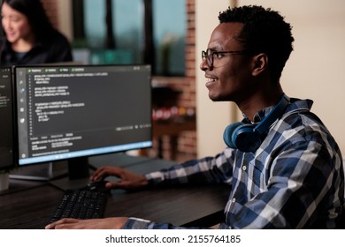 Smiling confident african american software engineer developing machine learning algorithm in order to sustain system security stability. Cyber developer creating network using binary encryption. - Shutterstock ID 2155764185