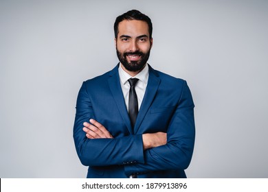 Smiling confident Arab businessman with arms crossed in formal clothes isolated over grey background - Shutterstock ID 1879913896