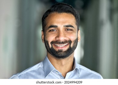 Smiling Confident Bearded Indian Businessman Looking At Camera Standing In Office. Classy Stylish Corporation Leader Successful Ceo Executive Manager Mentor Owner Posing. Headshot Business Portrait.