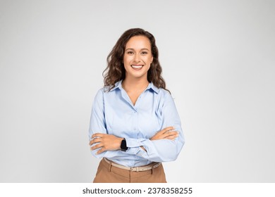 Smiling confident calm millennial european business woman, teacher in formal wear with crossed arms, isolated on gray background studio background. Work, education, ad and offer - Powered by Shutterstock