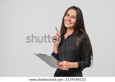 Smiling confident caucasian young businesswoman auditor writing on clipboard, signing contract document isolated in white background
