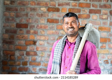 Smiling Confident Construction Worker Or Labour With Hose In Hands Turns By Looking Camera At Workplace - Concept Of Daily Wagers Lifestyle And Happiness