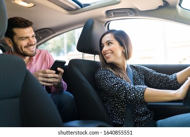 Smiling confident female driver talking with male customer in taxi - Shutterstock ID 1640855551