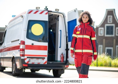 Smiling Confident Female Paramedic Walking Away From The EMS Vehicle