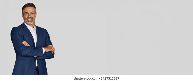 Smiling confident latin hispanic mature business man standing crossed arms isolated on grey background. Older senior businessman professional ceo, coach, leader looking at camera. Banner, copy space - Powered by Shutterstock