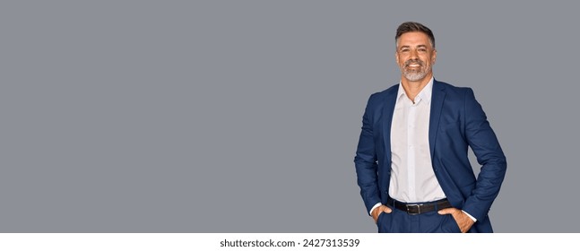 Smiling confident latin hispanic mature business man standing isolated on grey background. Older senior businessman, 40s 50s male professional ceo, coach, leader looking at camera. Banner, copy space. - Powered by Shutterstock