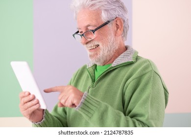 Smiling Confident Male With A Digital Tablet Held In His Hands Standing On Cute Background. White-haired Mature Caucasian Man With Glasses, College Student Of The Third Age University