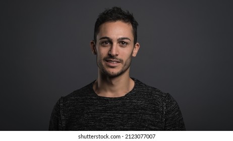 Smiling confident man close up portrait against dark grey background.