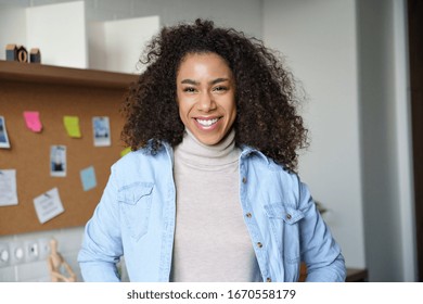 Smiling confident millennial african american woman look at camera standing at home office workspace with sticky notes. Happy mixed race female student professional designer freelancer portrait. - Powered by Shutterstock