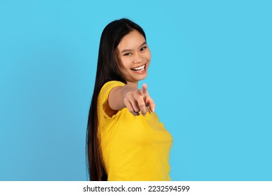 Smiling confident millennial korean lady in yellow t-shirt point finger at camera, isolated on blue background, studio. Your choice, your turn, challenge, great ad and offer, sale and human emotions - Shutterstock ID 2232594599