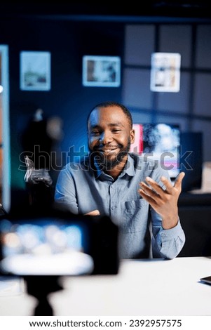 Smiling content creator using professional recording camera and microphone to do livestream and talk with fans. Online streamer using video production gear to do live broadcast for his subscribers