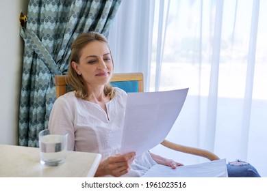 Smiling Contented Middle Aged Woman Reading Paper Letter