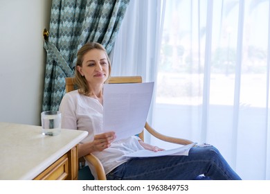 Smiling Contented Middle Aged Woman Reading Paper Letter