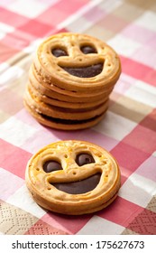 Smiling cookie face on a table with stack of cookies on a background