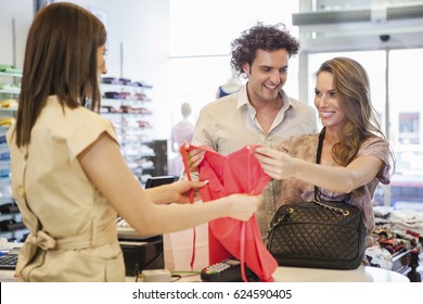 Smiling Couple Buying Clothes Together.