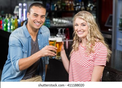 Smiling Couple Drinking Beer In A Bar