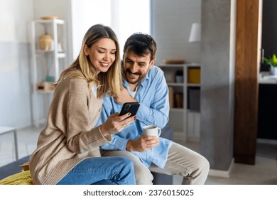 Smiling couple embracing while looking at smartphone. People sharing social media on smart phone. - Powered by Shutterstock