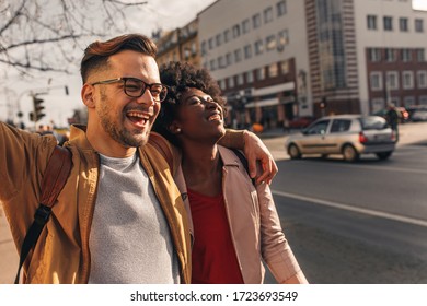 Smiling couple enjoying on vacation, young tourist having fun walking and exploring city street during the day.	