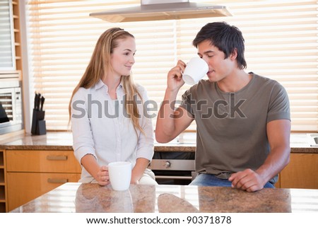 Smiling couple having a cup of coffee in their kitchen