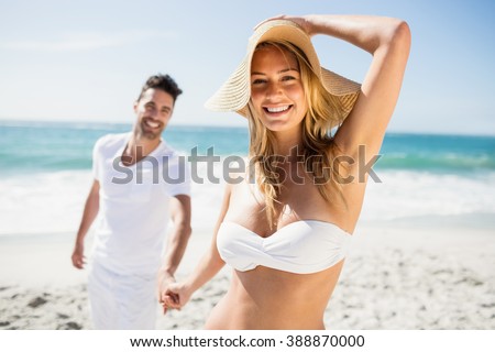 Smiling couple holding hands on the beach