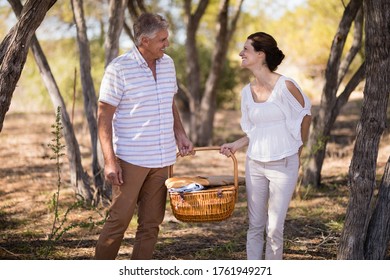 Smiling couple holding a wicker basket during safari vacation - Powered by Shutterstock